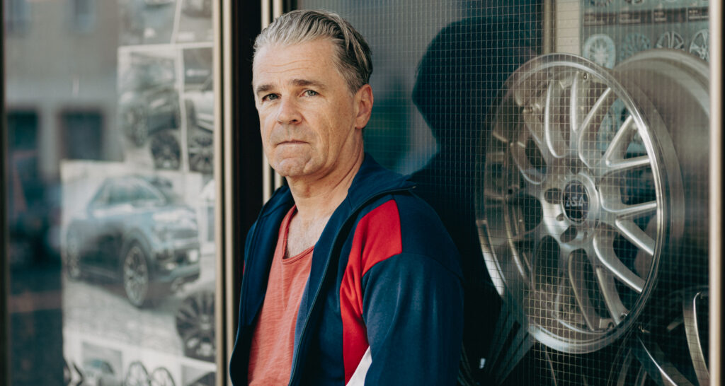 Schauspieler Männer Portrait mit cinematischen Look von Christian Himmelbauer vor Autogfelgen und Bildern von Autos
